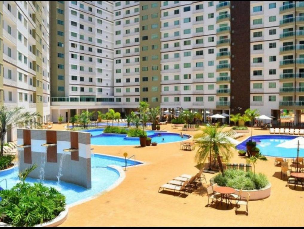 een resort met 2 zwembaden en een groot gebouw bij Riviera park Thermas Flat 1 in Caldas Novas