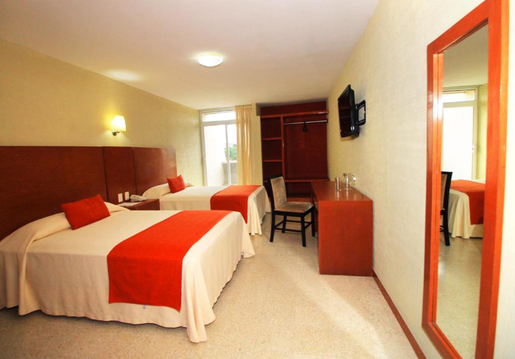 una camera d'albergo con due letti e un tavolo di Hotel Central a Veracruz