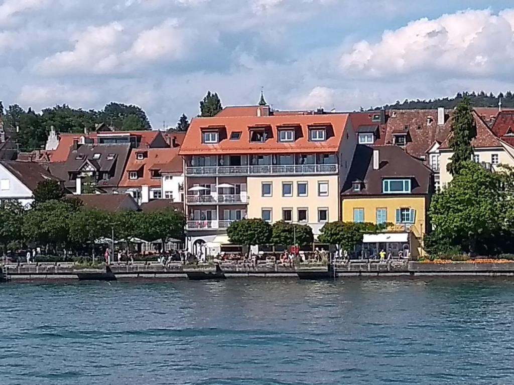 eine Gruppe von Gebäuden neben einem Wasserkörper in der Unterkunft Hotel Seegarten in Überlingen