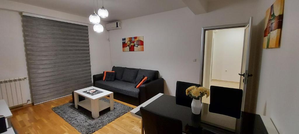 a living room with a couch and a table at Apartman Tri S in Arandjelovac