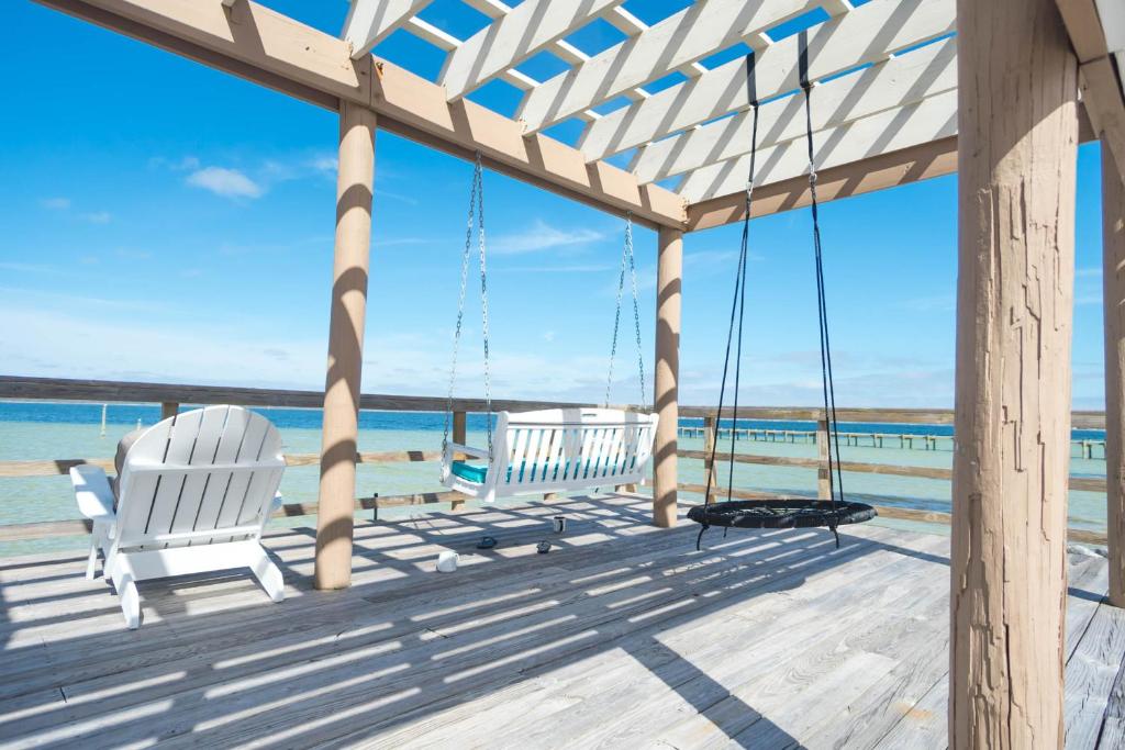 two chairs on a porch overlooking the beach at GetAways at Soundside Holiday Beach Resort in Pensacola Beach