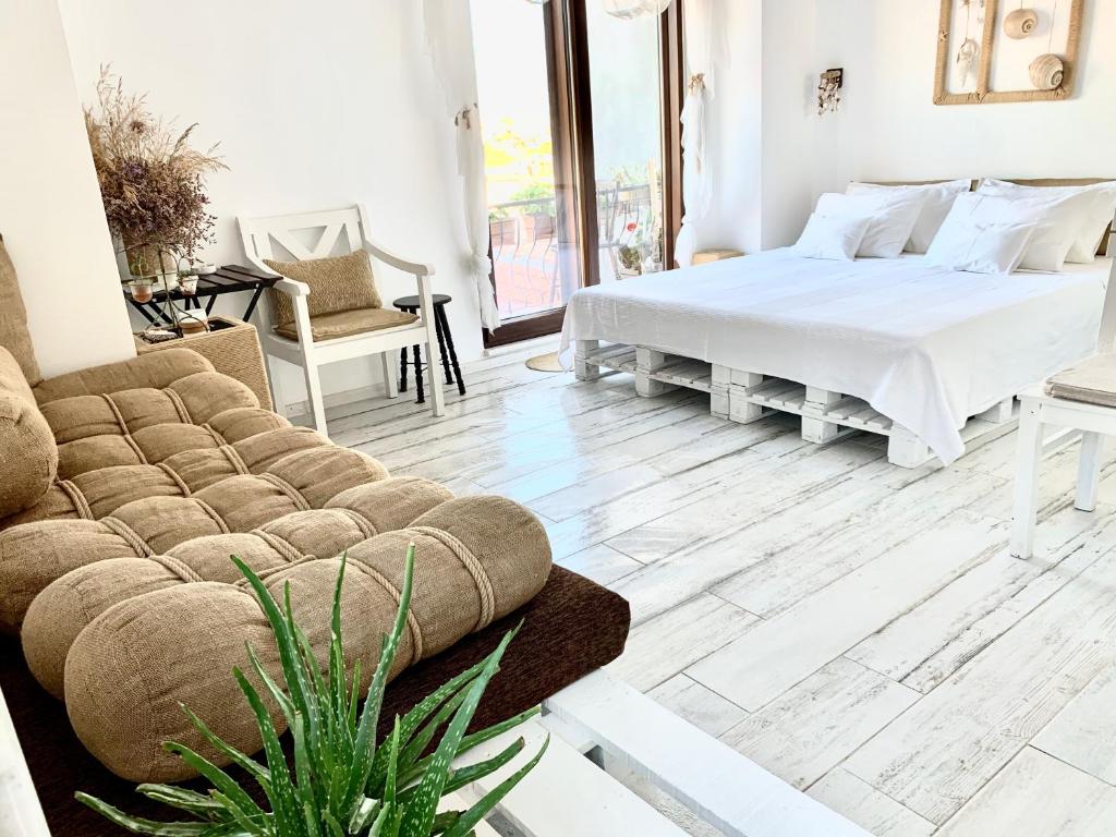 a bedroom with a bed and a couch at Vapori Otel in Bozcaada