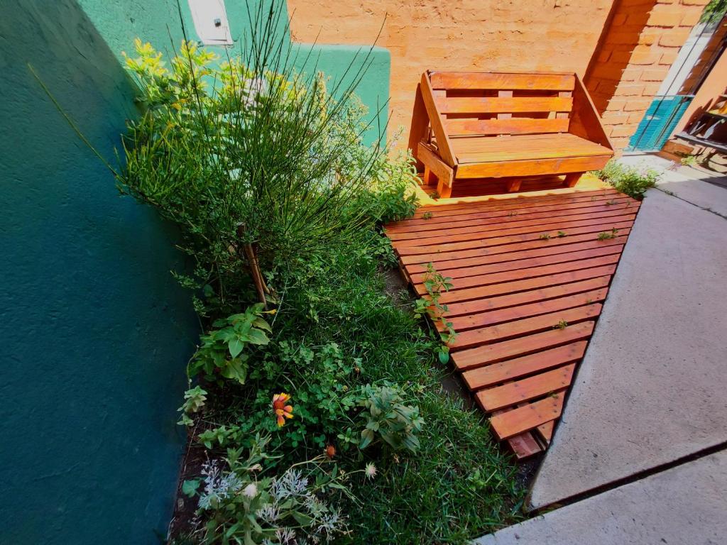 une terrasse en bois avec un banc et quelques plantes dans l'établissement Las Retamas - Viviendas Turísticas, à Zapala