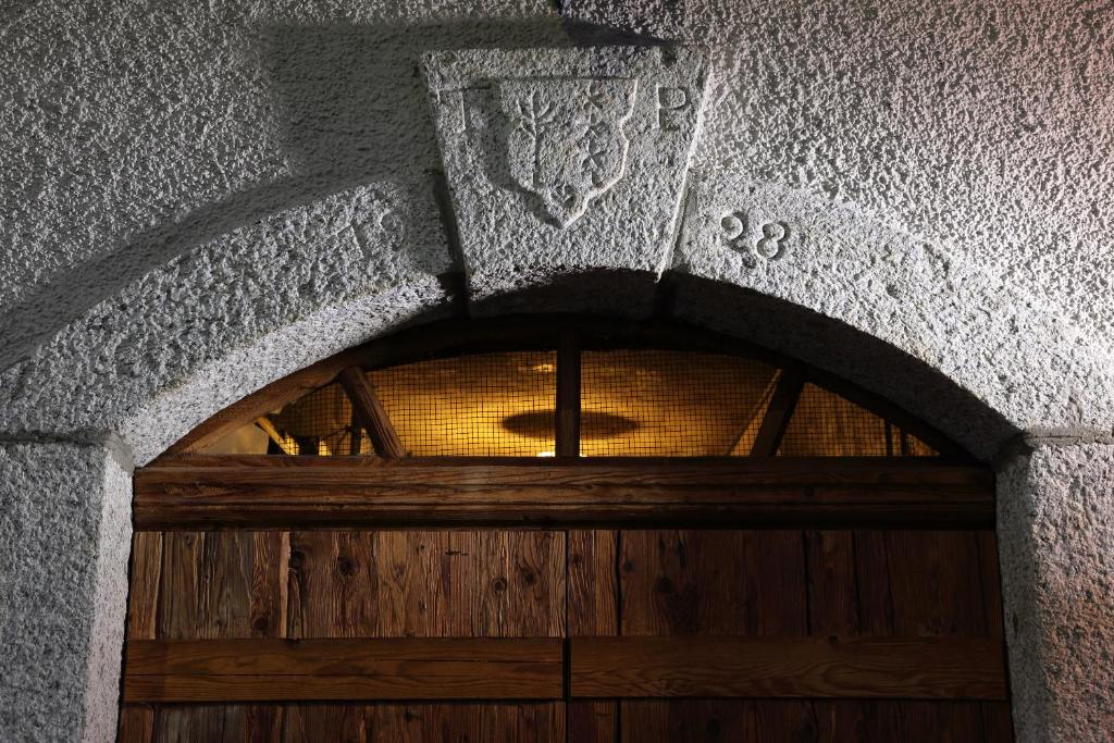 un arco sopra una porta di legno in un edificio di VISPERBLICK 24-7 Parkplatz und Frühstück inkl ad Ausserberg