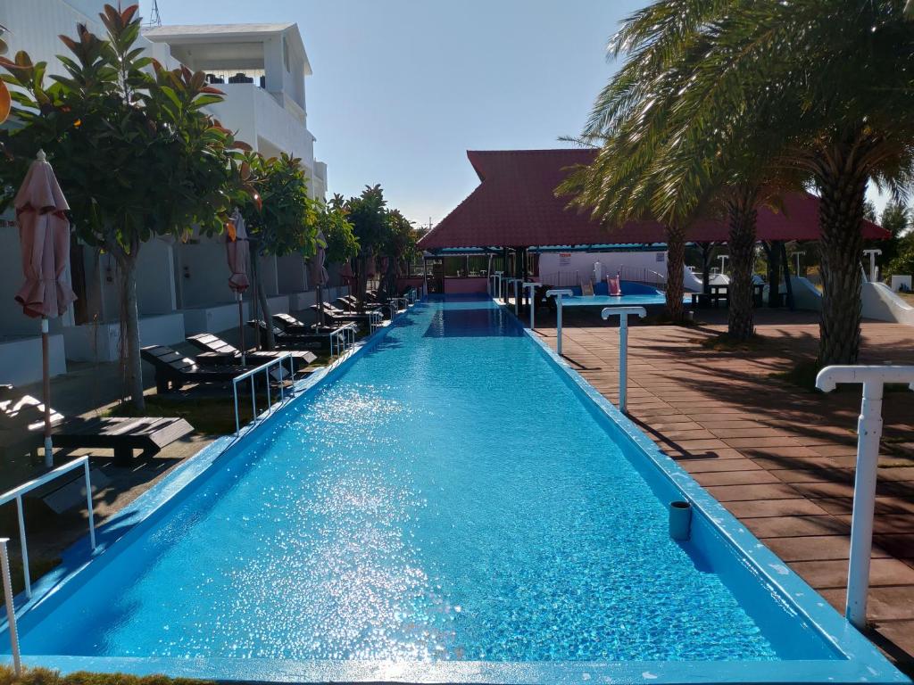 a swimming pool in a resort with palm trees at 象樹園農莊特色民宿 in Checheng