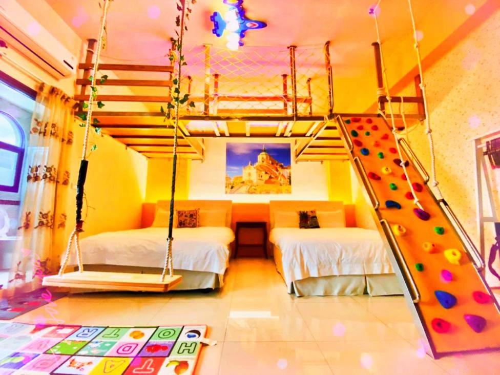 een slaapkamer met 2 bedden en een glijbaan bij Santorini Family Themed Inn in Taitung