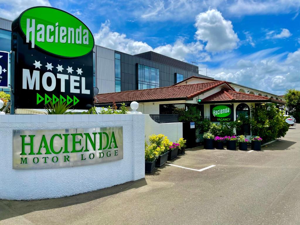 a hotel sign in front of a hotel at Hacienda Motor Lodge in Palmerston North