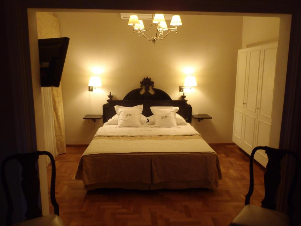 a bedroom with a bed with white pillows and a chandelier at GM Rooms Rental Suites in La Rioja