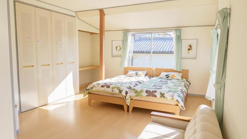 a bedroom with a bed and a window at サザンコースト湘南 in Chigasaki