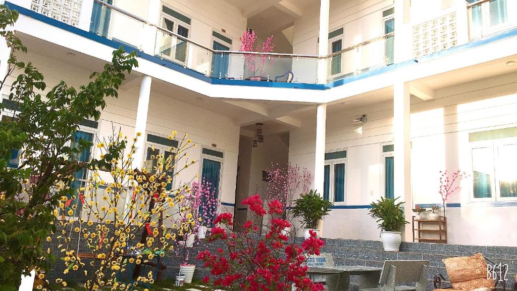 a building with flowers and plants in the courtyard at Minh Khoi Guest House in Mui Ne