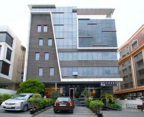 un bâtiment avec deux voitures garées devant lui dans l'établissement Ebony Boutique Hotel, à Hyderabad