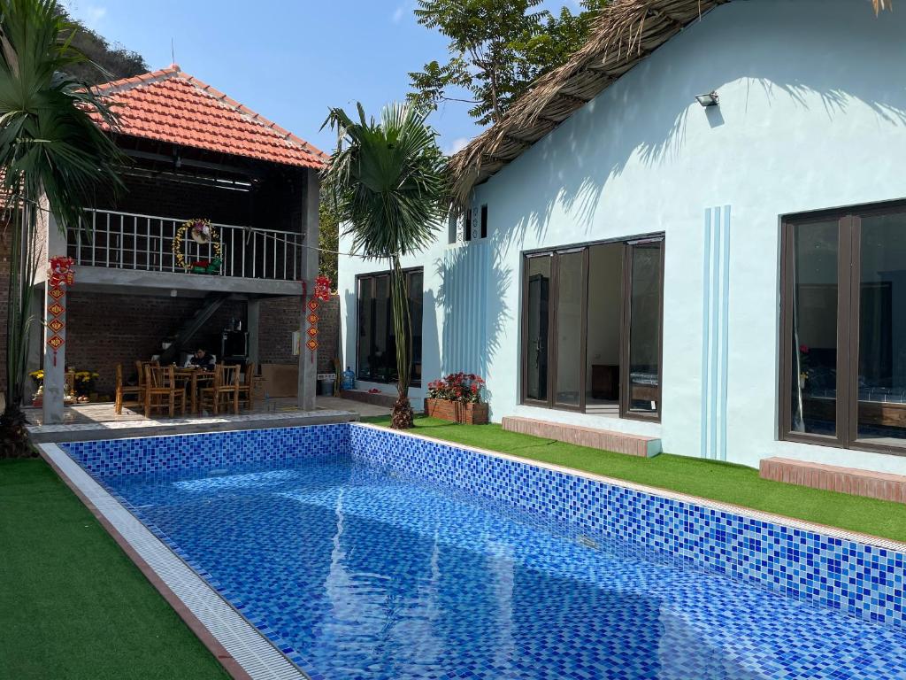 a swimming pool in front of a house at An Bungalow - Mai Châu in Hòa Bình