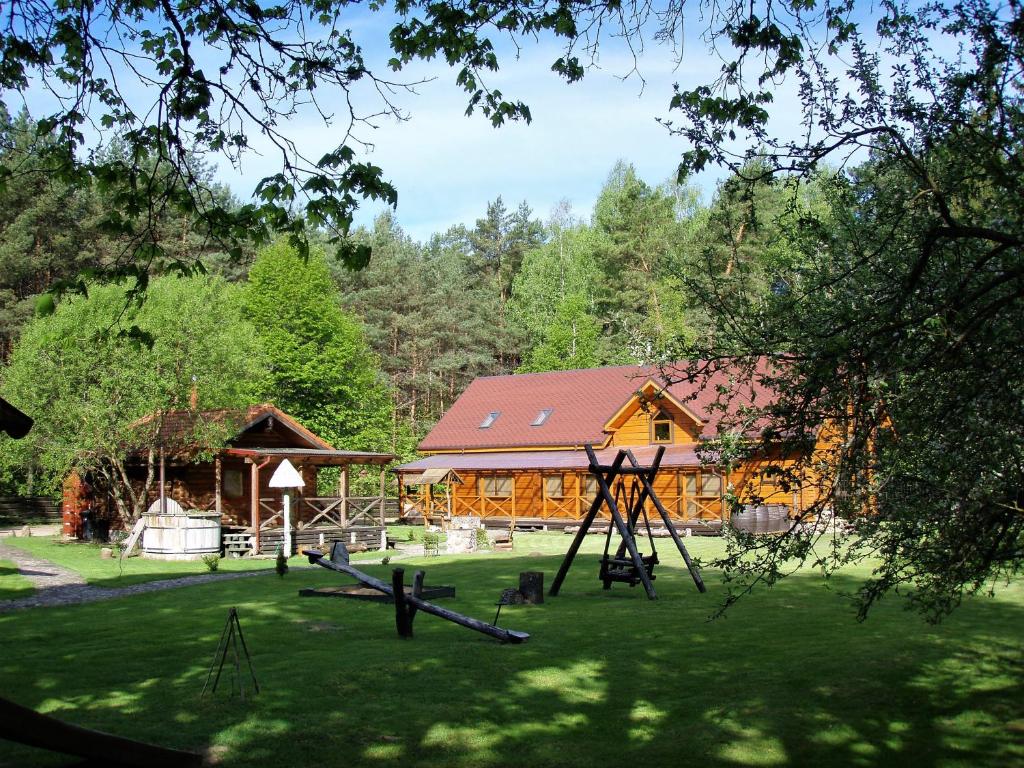 un parque infantil frente a un gran edificio de madera en Sodyba Duburiai en Ukmergė