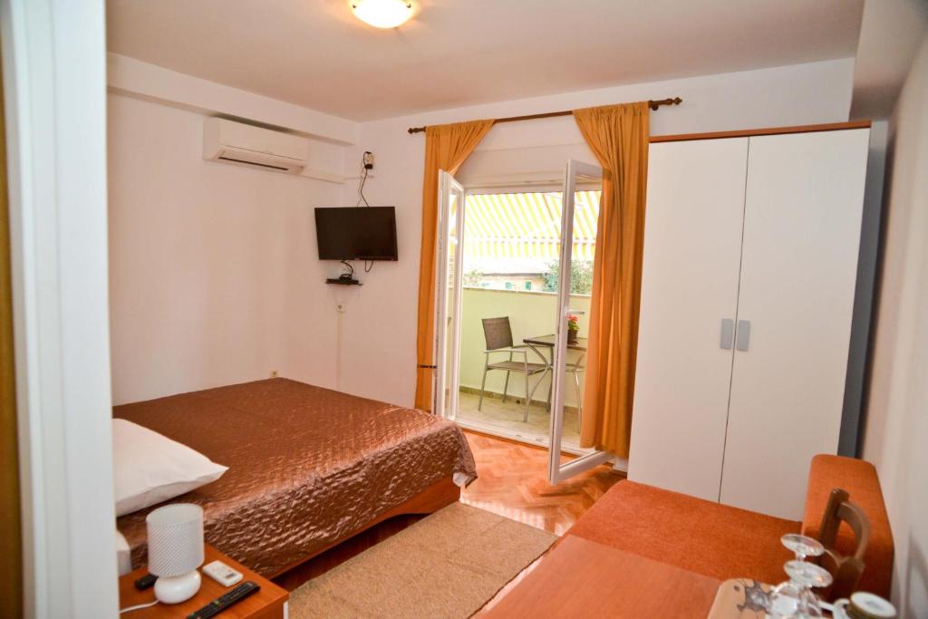 1 dormitorio con 1 cama y puerta corredera de cristal en El Mirador Rooms with Balcony, en Zadar