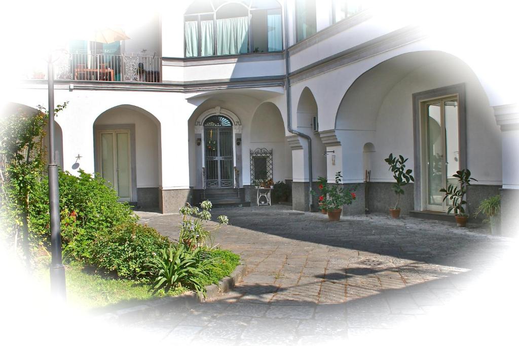 a white house with a brick walkway in front of it at Home La Corte in SantʼAntimo