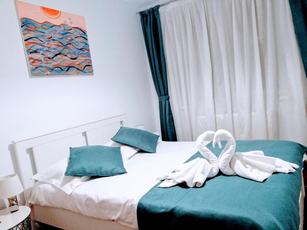 a bedroom with a bed with a white towel on it at Promenada Apartment in Constanţa