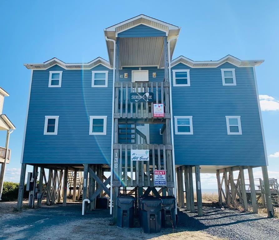a blue building on the beach with trash at Serenitee in Holden Beach