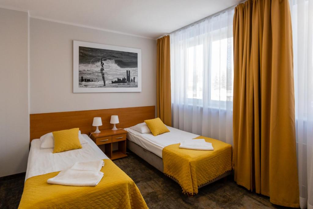 a hotel room with two beds and a window at Hotel Sport in Koszalin