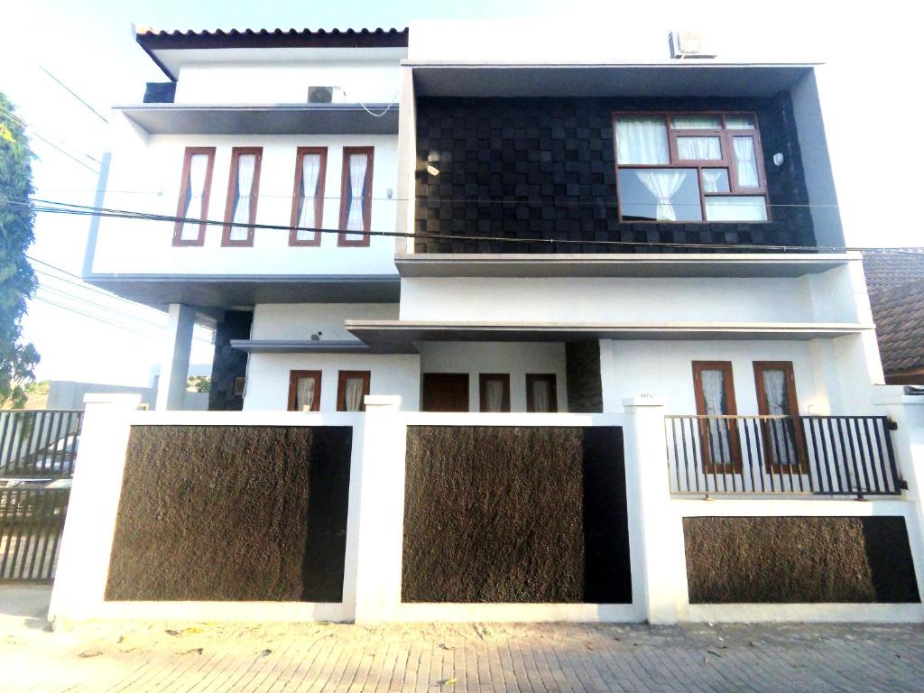 uma casa branca com uma cerca à frente. em South City Homestay in Wirokerten em Bantul
