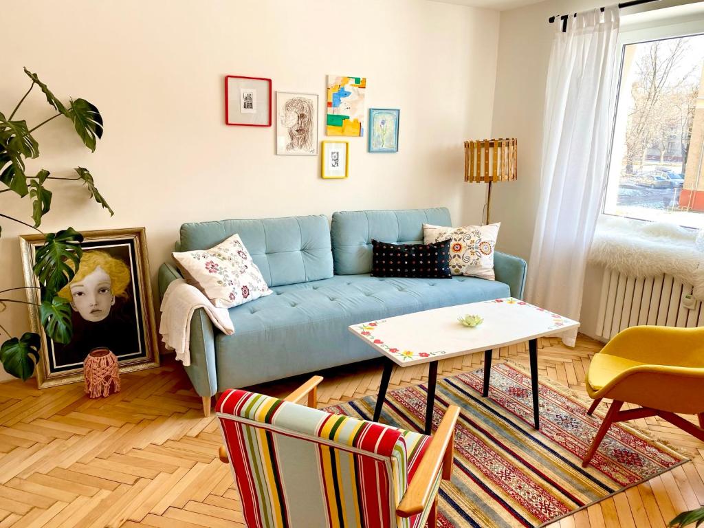 a living room with a blue couch and a table at Chyža retro apartmán in Prievidza