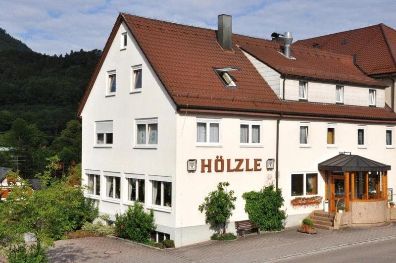 a large white building with a brown roof at Landgasthof Hölzle in Waldstetten