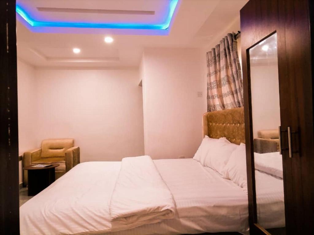 um quarto com uma cama com uma luz azul em Big Ocean Inn em Ibadan