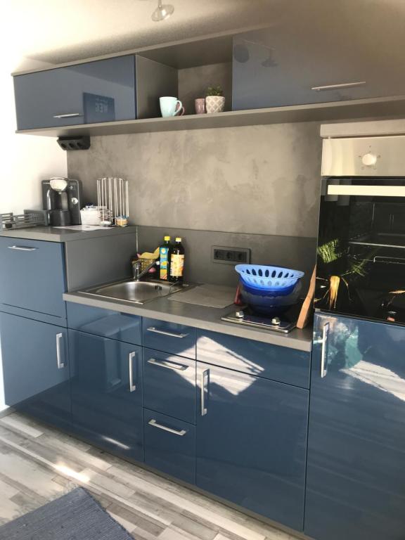 a kitchen with blue cabinets and a sink at Haus Friedel Überlingen am Bodensee in Überlingen