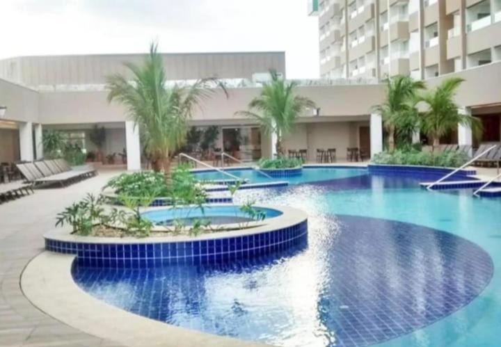 una gran piscina de agua azul en un edificio en Olimpia Apartamentos, en Olímpia