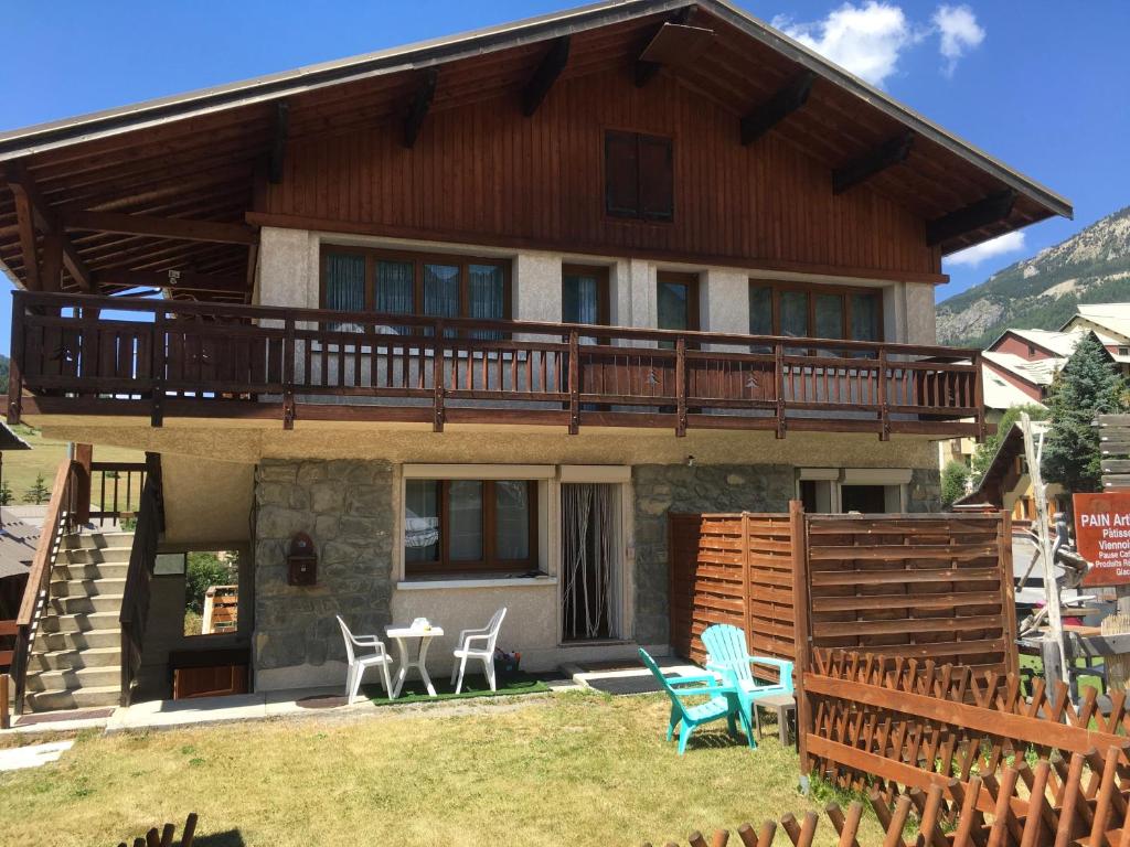 a house with a deck and chairs in front of it at Chalet Changalan in Vars