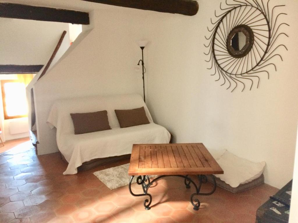 a bedroom with a bed and a table and a mirror at LA MAISON D’ALICE in Sault-de-Vaucluse