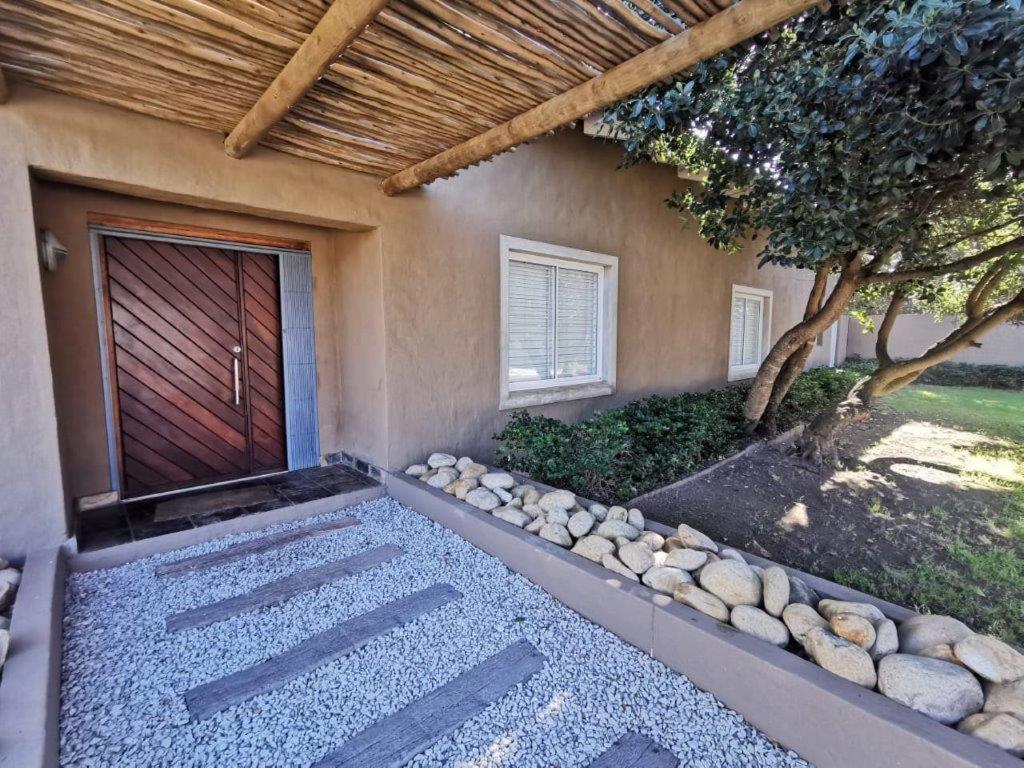 a building with a wooden door and a stone walkway at Brander View in Hermanus