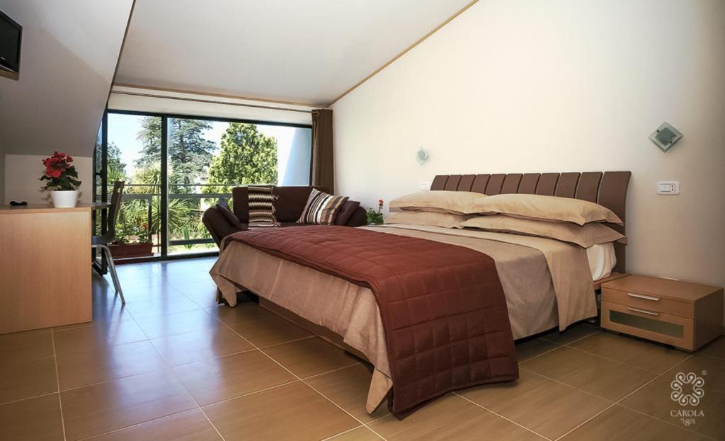 a bedroom with a large bed and a large window at Vecchio Saracino - Carola 1801 in Agropoli