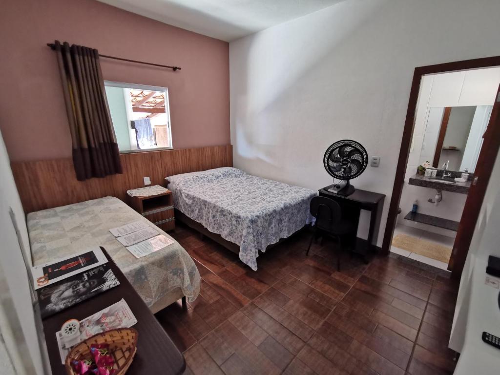 a small bedroom with a bed and a mirror at Suíte Capitólio in Capitólio