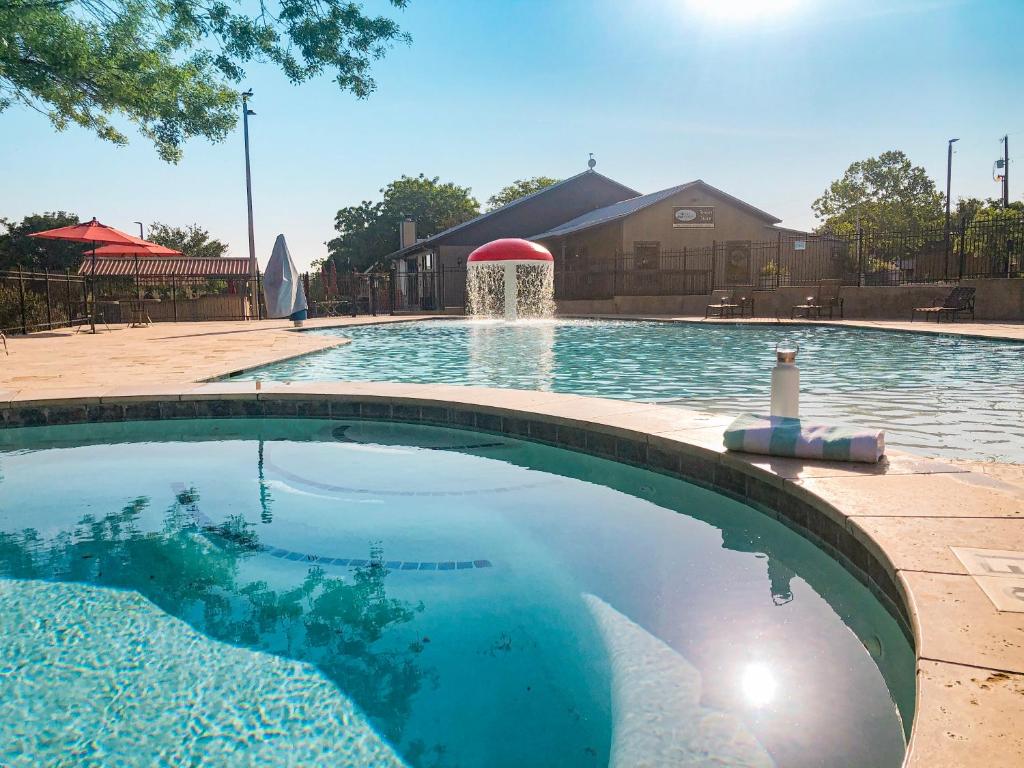 a swimming pool with a fountain in the middle at Sun Retreats Texas Hill Country in New Braunfels