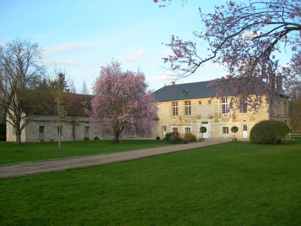 una gran casa de piedra con césped verde en Gite et Chambres d'Hôtes Clos de Mondetour, en Fontaine-sous-Jouy