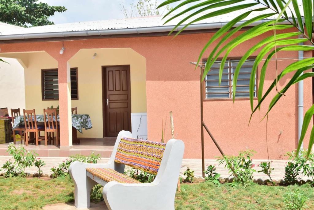 un banco sentado frente a una casa en Akwa Guesthouse Cotonou, en Cotonou