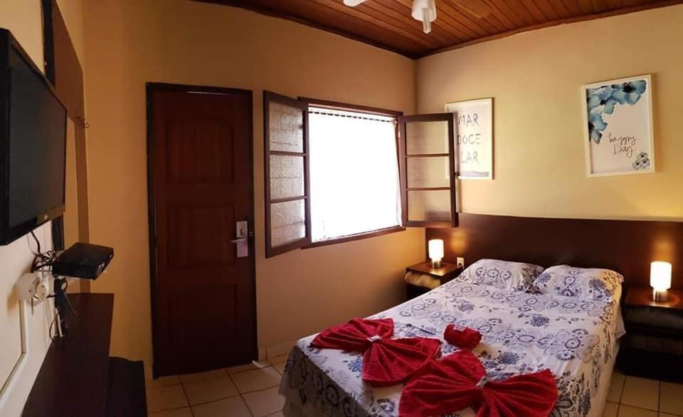 a bedroom with a bed with red bows on it at Vento Sul in Abraão