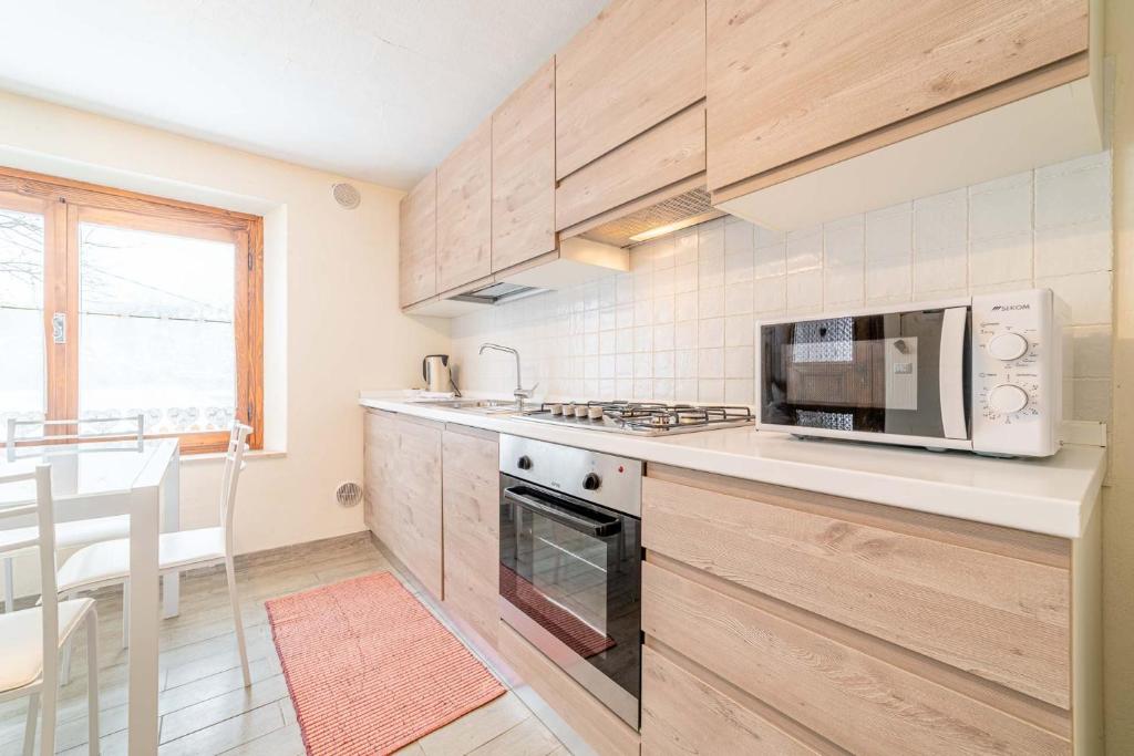 a kitchen with a microwave and a stove top oven at Appartamento Dei Pini in Alleghe