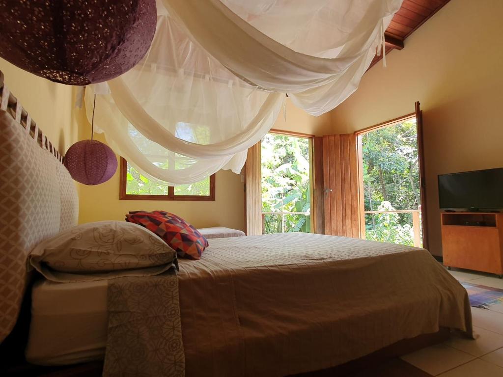 1 dormitorio con cama y ventana grande en Vila Esperança en Vale do Capao