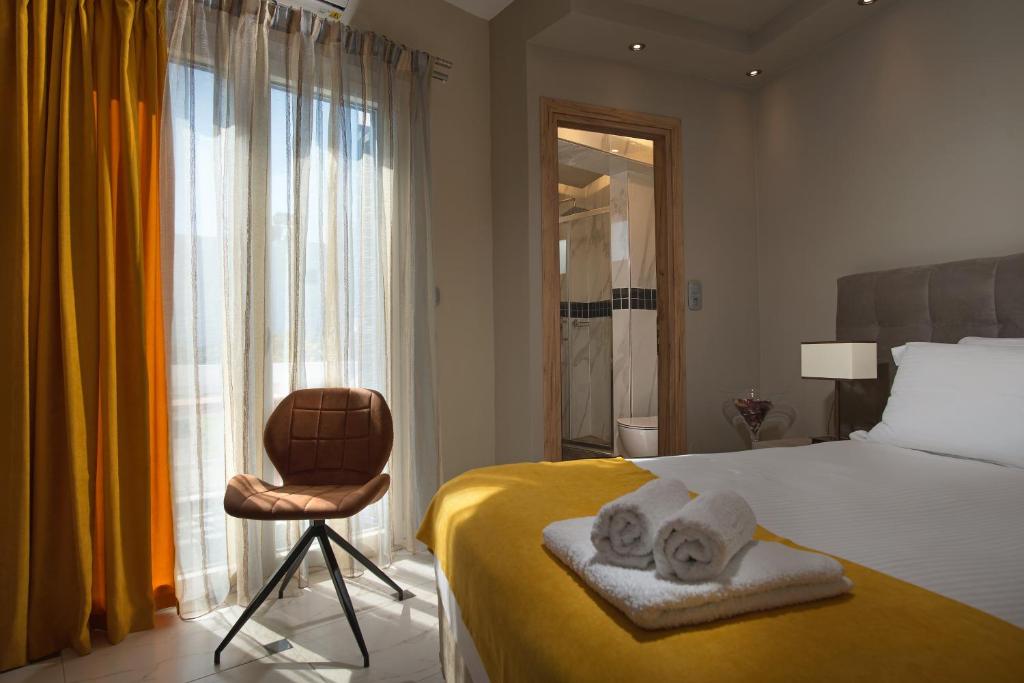 a bedroom with a bed and a chair and a window at Angelica's Deluxe Rooms in Adamas in Adamas
