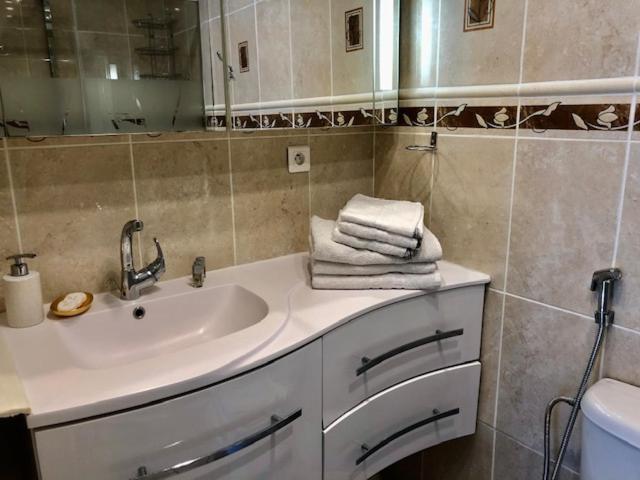 a bathroom with a sink and a mirror and towels at Charmant Studio à Uchaud in Uchaud