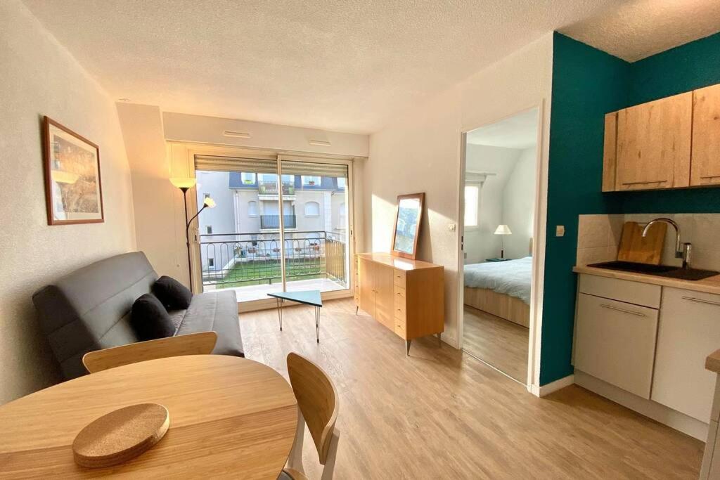 sala de estar con sofá, cama y cocina en Logement 4 lits en plein coeur de Cabourg en Cabourg