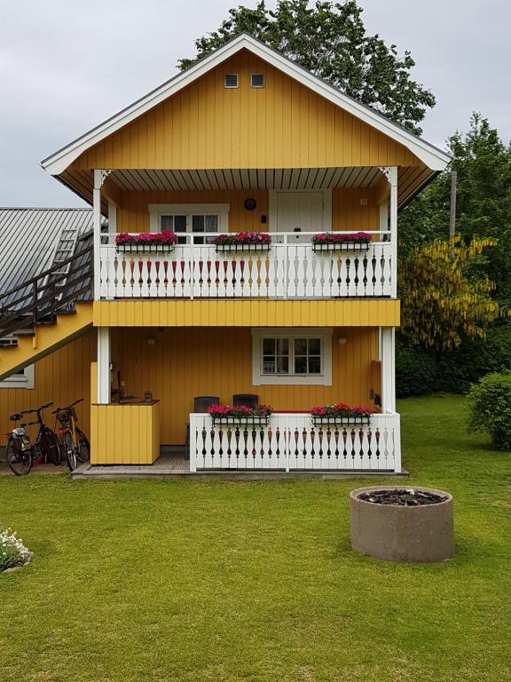 a yellow house with a balcony with flowers on it at Nostalgirum in Kil
