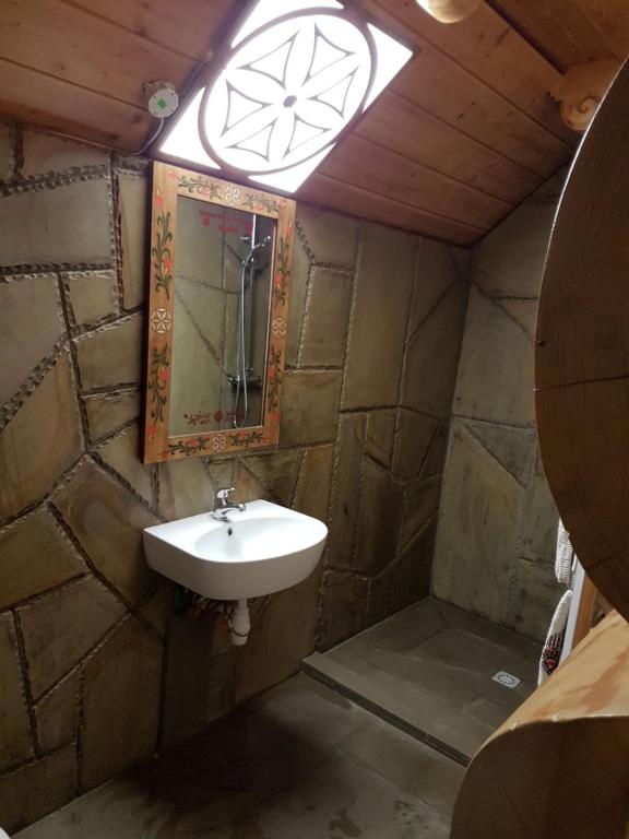 a bathroom with a sink and a mirror at APARTAMENT SZAŁAS BACIARSKI z tarasem i widokim na GÓRY in Poronin