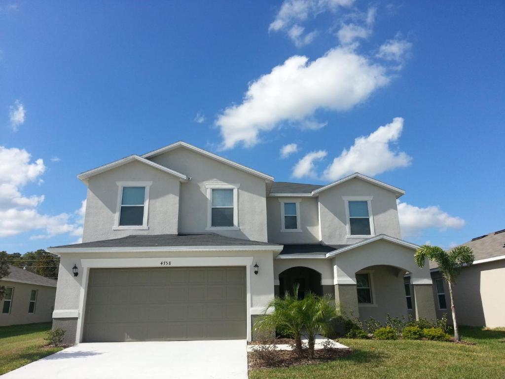 a white house with a garage at CozyKey Vacation Rentals - Crystal Cove in Kissimmee