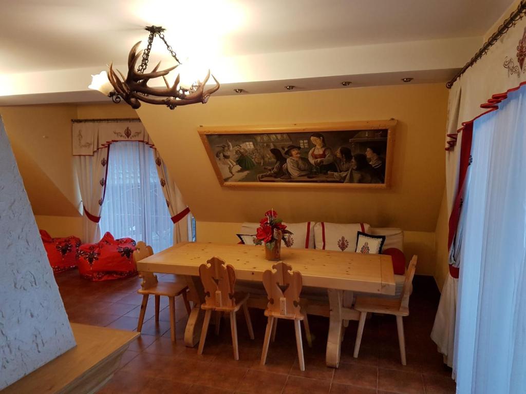 a dining room with a table and chairs at Apartamenty Baciarskie in Poronin