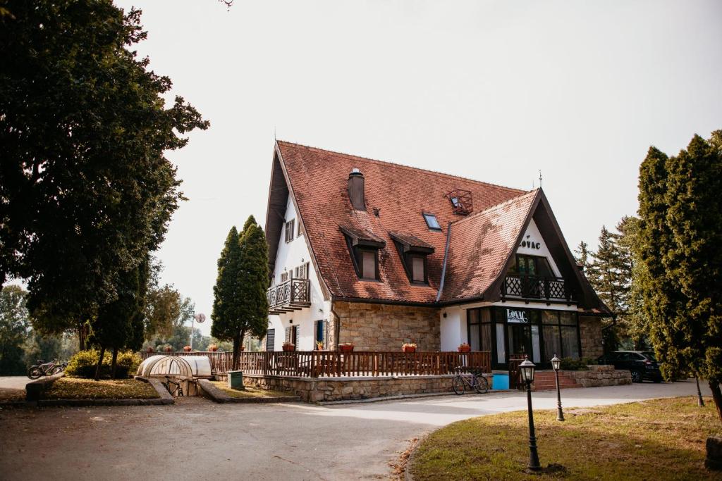 ein großes Haus mit braunem Dach in der Unterkunft Restoran Lovac in Novi Kneževac