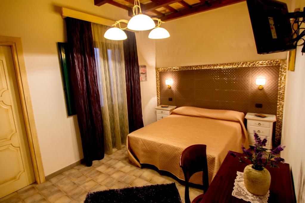 a bedroom with a bed and a table and lights at Vicolo del Porto in Lampedusa