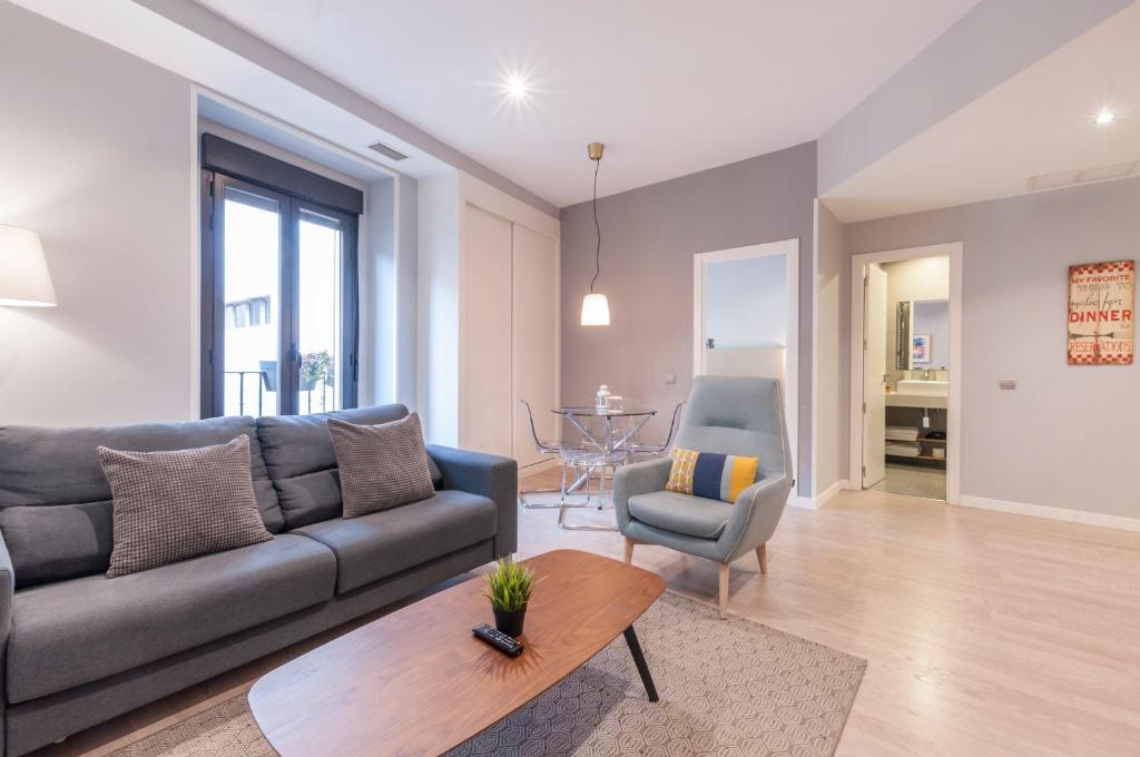 a living room with a couch and a table at Arenal Suites Puerta del Sol in Madrid