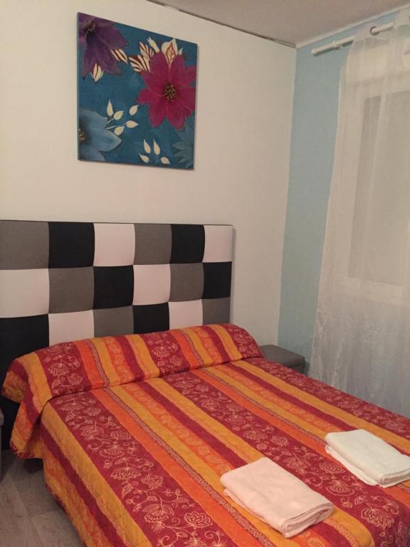 - une chambre avec un lit orné d'une peinture florale sur le mur dans l'établissement Chez Grand Mere, à Le Perthus